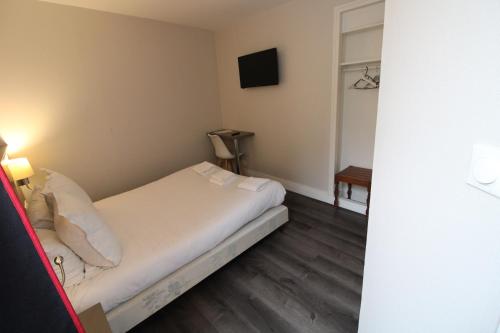 a small room with a bed and a television at Hôtel Casabianca in Moulins