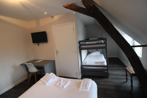 a bedroom with a bed and a bunk bed with a ladder at Hôtel Casabianca in Moulins