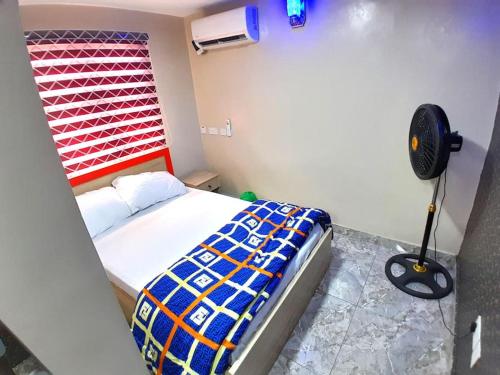 a bedroom with a bed with a red headboard and a fan at MQ Apartments-Cozy 2 bedrooms in Lagos