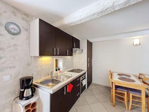 une cuisine avec un évier et un plan de travail dans l'établissement Maison de village climatisée, à Villeneuve-Loubet