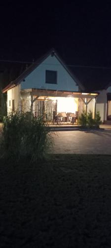 a house with a light on the front of it at night at Domki u Eweli CAŁOROCZNE ogrzewane kominkiem in Stegna