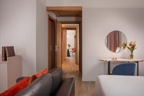 a living room with a couch and a table at NH Catania Centro in Catania