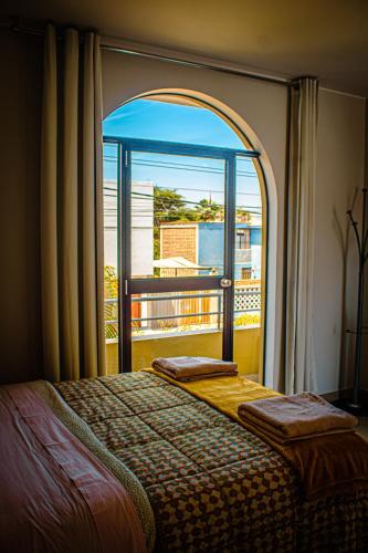 a bedroom with two beds and a large window at DEL VALLE HOUSE II in Ica