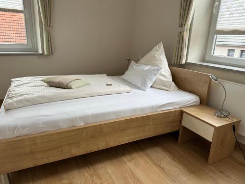 a bed with white sheets and pillows in a room at Gasthof Kreisi in Friedberg