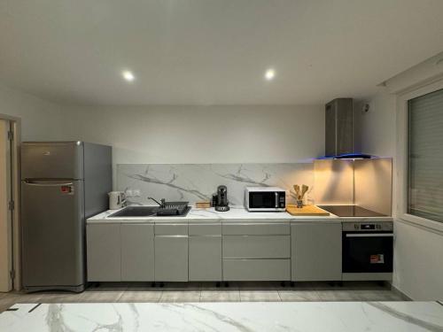 une cuisine avec un évier et un micro-ondes dans l'établissement Grand appartement spacieux - Aubenas, à Aubenas