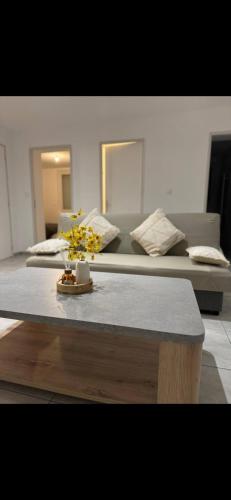 Cette chambre comprend un lit et une table fleurie. dans l'établissement Grand appartement spacieux - Aubenas, à Aubenas