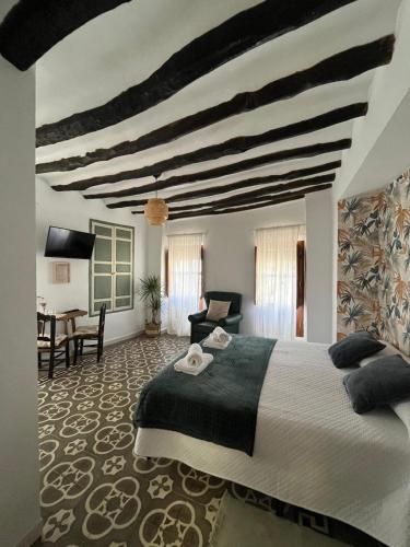 a bedroom with a large bed and a desk at Alojamiento La Escalera in Alhama de Granada
