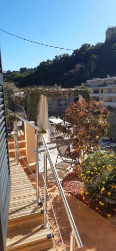 une terrasse en bois avec des chaises et des arbres dans un bâtiment dans l'établissement Chambre d'hôtes, à Menton
