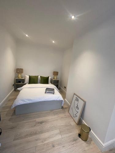 a bedroom with a large bed and wooden floors at Luxury double room in modern renovated house in Catford