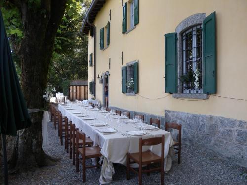 una mesa larga con mesas blancas y sillas frente a un edificio en Ristorante Hotel Falchetto, en Brunate
