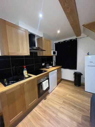 une cuisine avec des armoires en bois et un four à plaques de cuisson dans l'établissement Maison du Tripot, à Ligny-en-Barrois