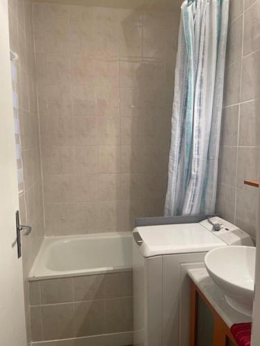 une salle de bain avec un lavabo, une baignoire et des toilettes dans l'établissement Un Cottage à la Mer, au Pouliguen
