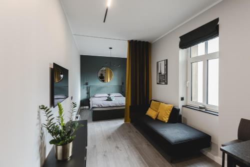 リガにあるDzirnavu Apartmentのベッドとソファのあるリビングルーム