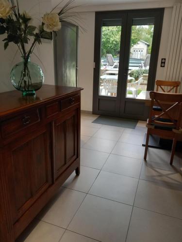 - un salon avec un vase sur une commode et une porte dans l'établissement Bella Loire, à Le Monteil