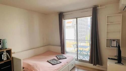 une chambre avec un lit et une fenêtre avec un balcon dans l'établissement Studio Stone Brooke, à La Grande Motte