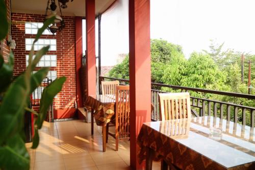 a porch with a table and chairs on a balcony at The Homey Rooms and Tours in Yogyakarta