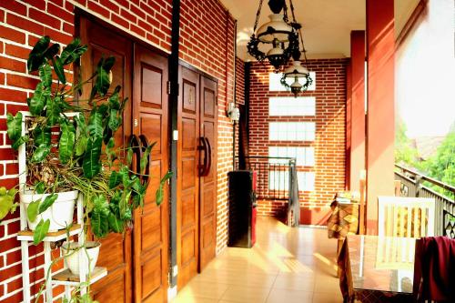 a hallway with a brick wall and a wooden door at The Homey Rooms and Tours in Yogyakarta