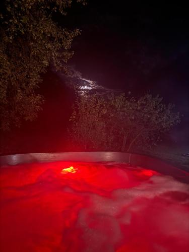 a hot tub filled with red liquid at night at PENSIUNEA DIMITRIOS Relaxare cu jacuzzi pe Valea Cernei in Băile Herculane
