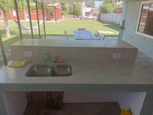 a kitchen counter with a sink in a yard at La casita de duggan in Duggan
