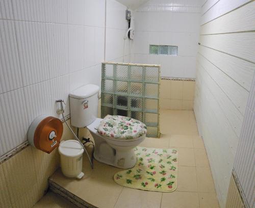łazienka z toaletą z fotelem kwiatowym w obiekcie Balmy Hideout Cafe'& Homestay w mieście Ban Huai Kaeo