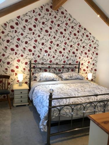 a bedroom with a bed with a floral wallpaper at The Nook in Padstow
