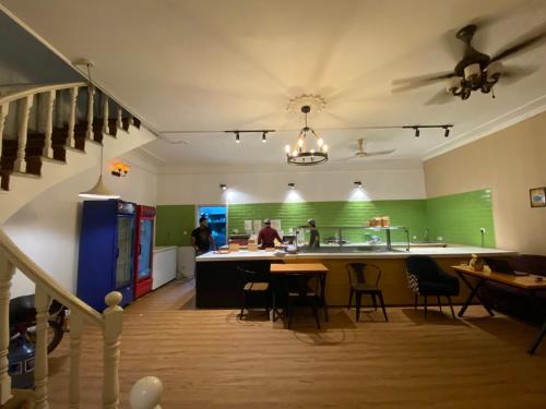 a kitchen with green walls and a table and chairs at Hotel Swan Suites in Lahore