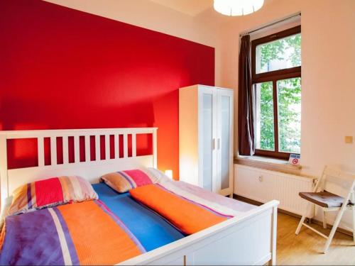 a bedroom with a red wall and a bed at Im Herzen - Zentral in Leipzig in Leipzig