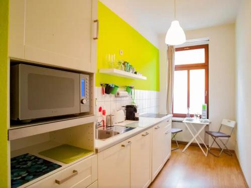 a kitchen with a sink and a tv on a wall at Im Herzen - Zentral in Leipzig in Leipzig