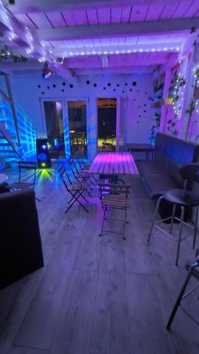 a room with chairs and tables and purple lights at ZAPPA na savi in Pe°ani