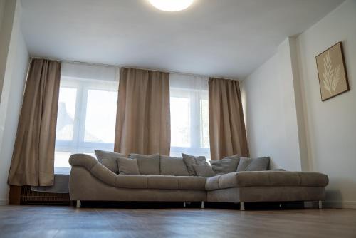a living room with a couch in front of a window at FeWo 10P Küche TV WF in Salzbergen