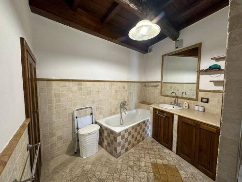 bagno con vasca, lavandino e specchio di La Civetta - Casa vacanze Orte a Orte