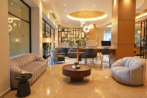 a lobby with couches and a table and chairs at HB Xalapa in Xalapa