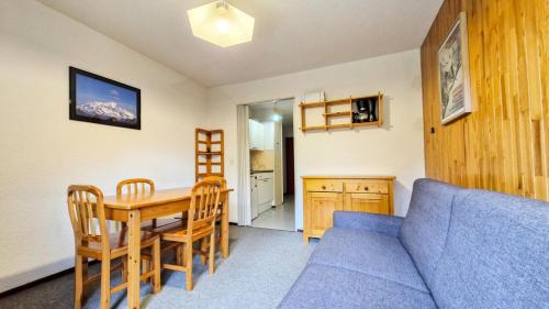 un salon avec une table et un canapé bleu dans l'établissement Résidence Pollux - Studio confortable avec cabine · Proche des pistes et des commerces · Balcon MAE-7415, à Flaine