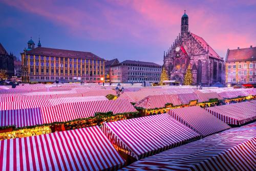 a group of red and white umbrellas in a city at Falk Homes- Luxus Apartments, ideal für Geschäftsreisende & Familien - nahe Messe, im Zentrum Nürnbergs mit Balkon, Arbeitsplatz & Parkplatz, Handtücher & Bettwäsche, nähe Playmobilfunpark, self check-in in Nürnberg