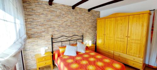 a bedroom with a bed and a brick wall at La Casita de Benatae in Benatae