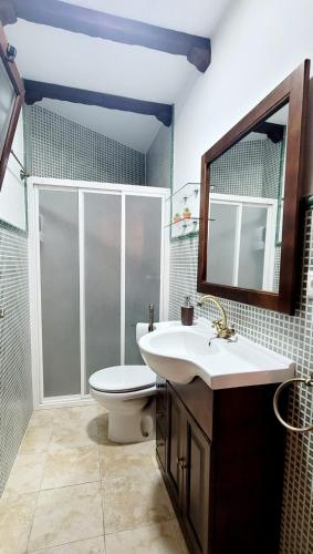 a bathroom with a sink and a toilet and a mirror at La Casita de Benatae in Benatae