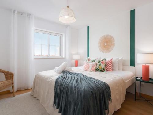 a white bedroom with a large bed with pillows at Sweet Summer Apartment - Cabanas in Cabanas de Tavira