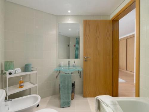 a bathroom with a sink and a toilet and a tub at Sweet Summer Apartment - Cabanas in Cabanas de Tavira