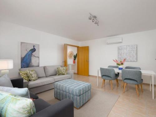 a living room with a couch and a table and chairs at Sweet Summer Apartment - Cabanas in Cabanas de Tavira