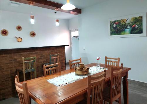 a dining room with a wooden table and chairs at Temporada Belas Casas in São Pedro