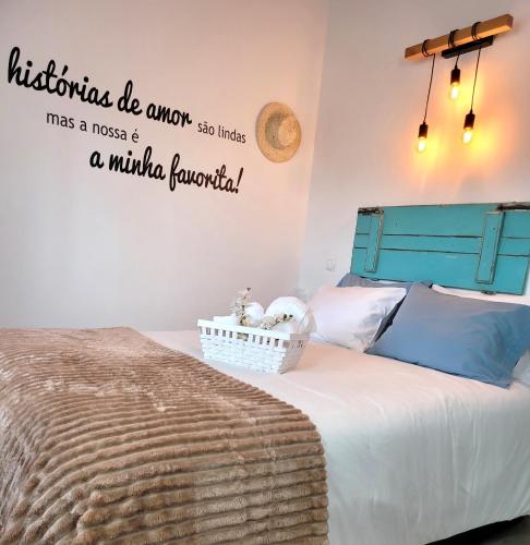 a bedroom with a bed with a blue headboard at Casinha da Esquina - Refúgio Alentejano a 700m da Praia in Amieira