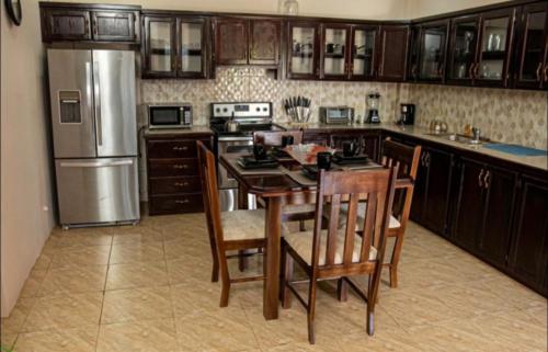a kitchen with a table and chairs and a refrigerator at Casa De Llewellyn's Apartments in Kelly Village