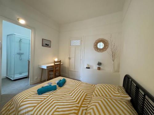 une chambre avec un lit avec des oreillers bleus dessus dans l'établissement Au Galop - Proche stade équestre, à Vichy