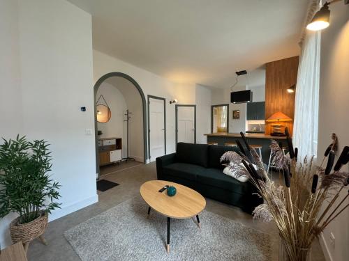 un salon avec un canapé vert et une table dans l'établissement Au Galop - Proche stade équestre, à Vichy