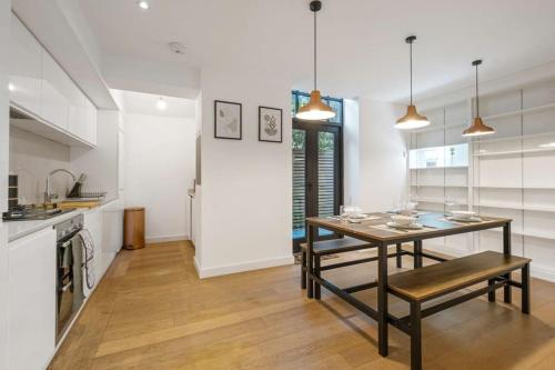 a dining room with a table and a kitchen at Lux Barn Conversion in Frodsham in Frodsham