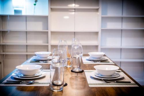 a table with glasses and plates and bowls on it at Lux Barn Conversion in Frodsham in Frodsham