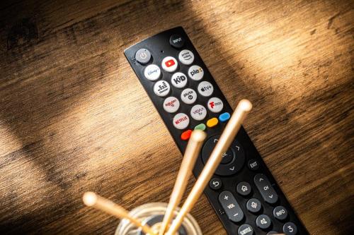 a remote control sitting on a wooden table with chopsticks at Lux Barn Conversion in Frodsham in Frodsham