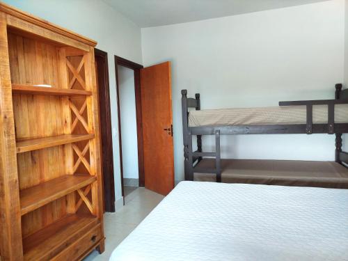 a bedroom with a bunk bed and a wooden door at Temporada Belas Casas in São Pedro