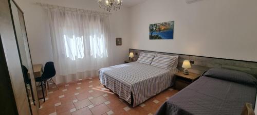 een kleine slaapkamer met een bed en een raam bij Villa Virginia Porto Pino in Porto Pino