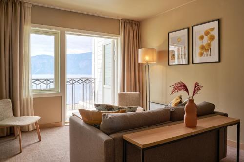 a living room with a couch and a large window at Vøringfoss Hotel in Eidfjord
